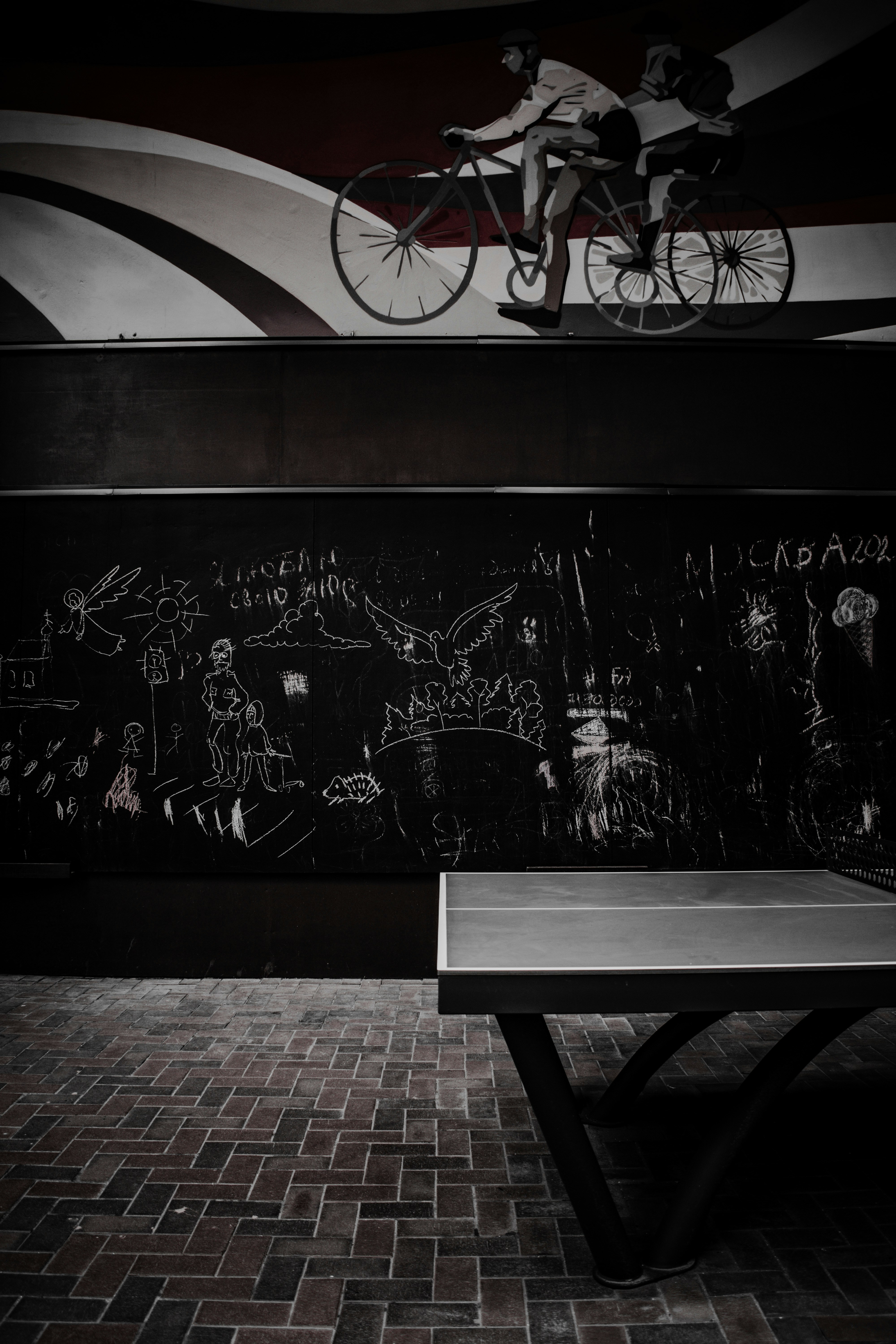 a black and white photo of a man riding a bike