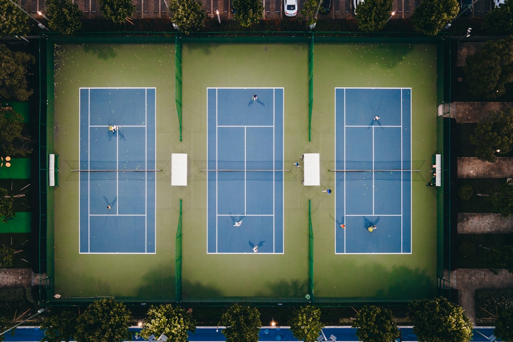 an aerial view of two tennis courts in a park
