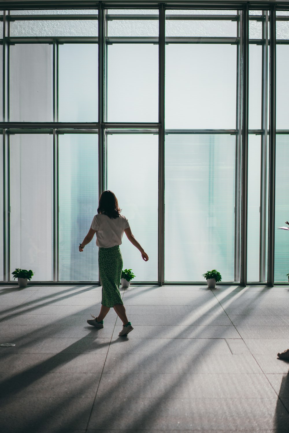 a woman in a white shirt and a green skirt