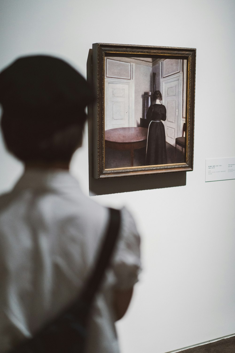 a person looking at a painting on a wall