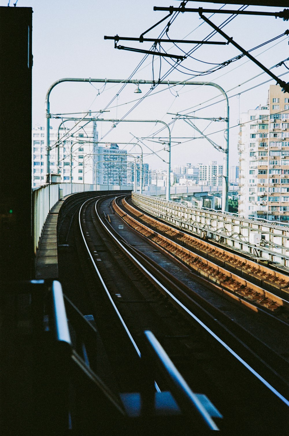 a train track running through a city with tall buildings