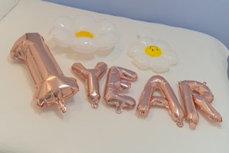 A balloon centerpiece shaped like a teddy bear holding a '1' balloon.