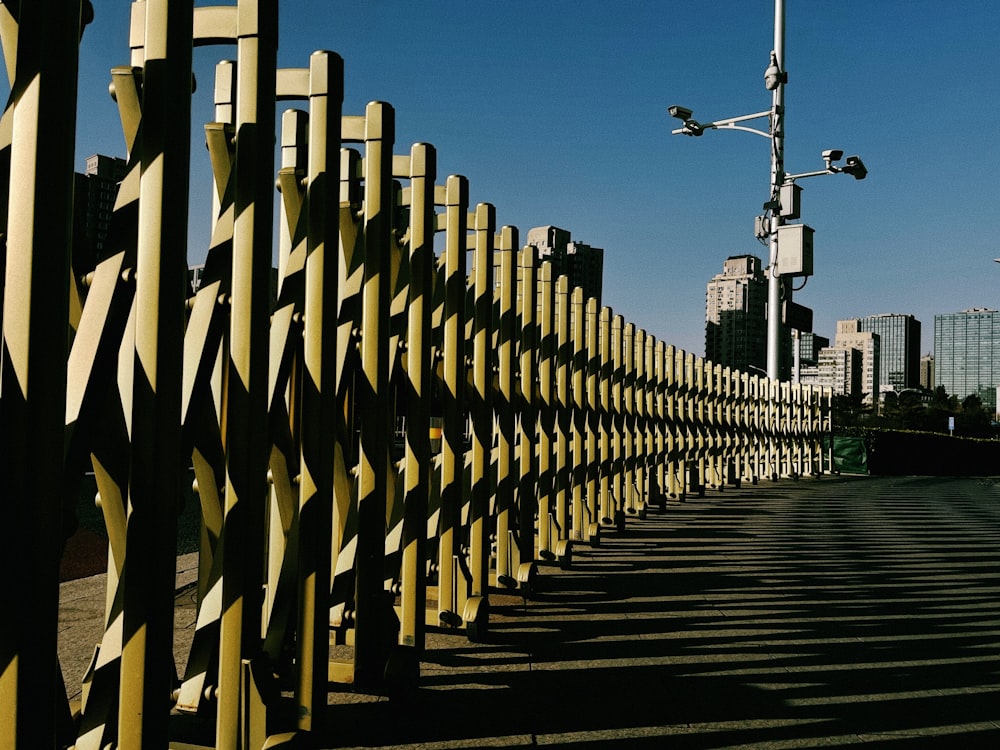 a yellow fence with a city in the background