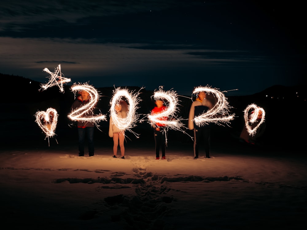 a group of people standing next to each other holding sparklers