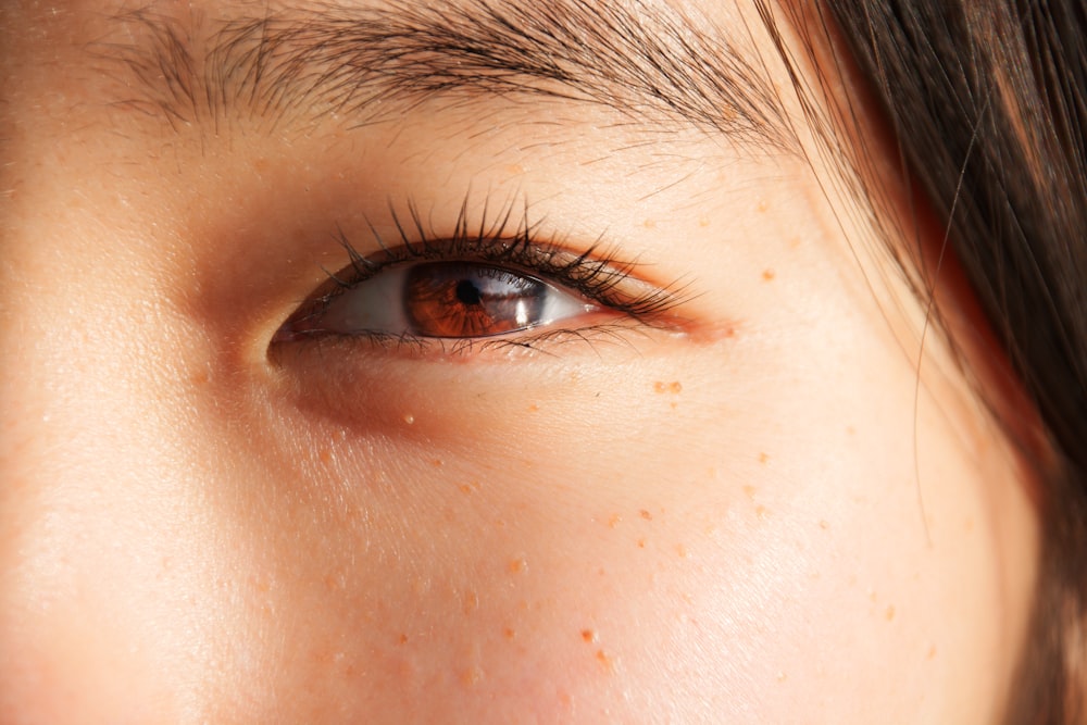 a close up of a woman's brown eye