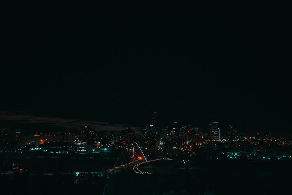 Blick auf eine Stadt bei Nacht von einem Hügel aus