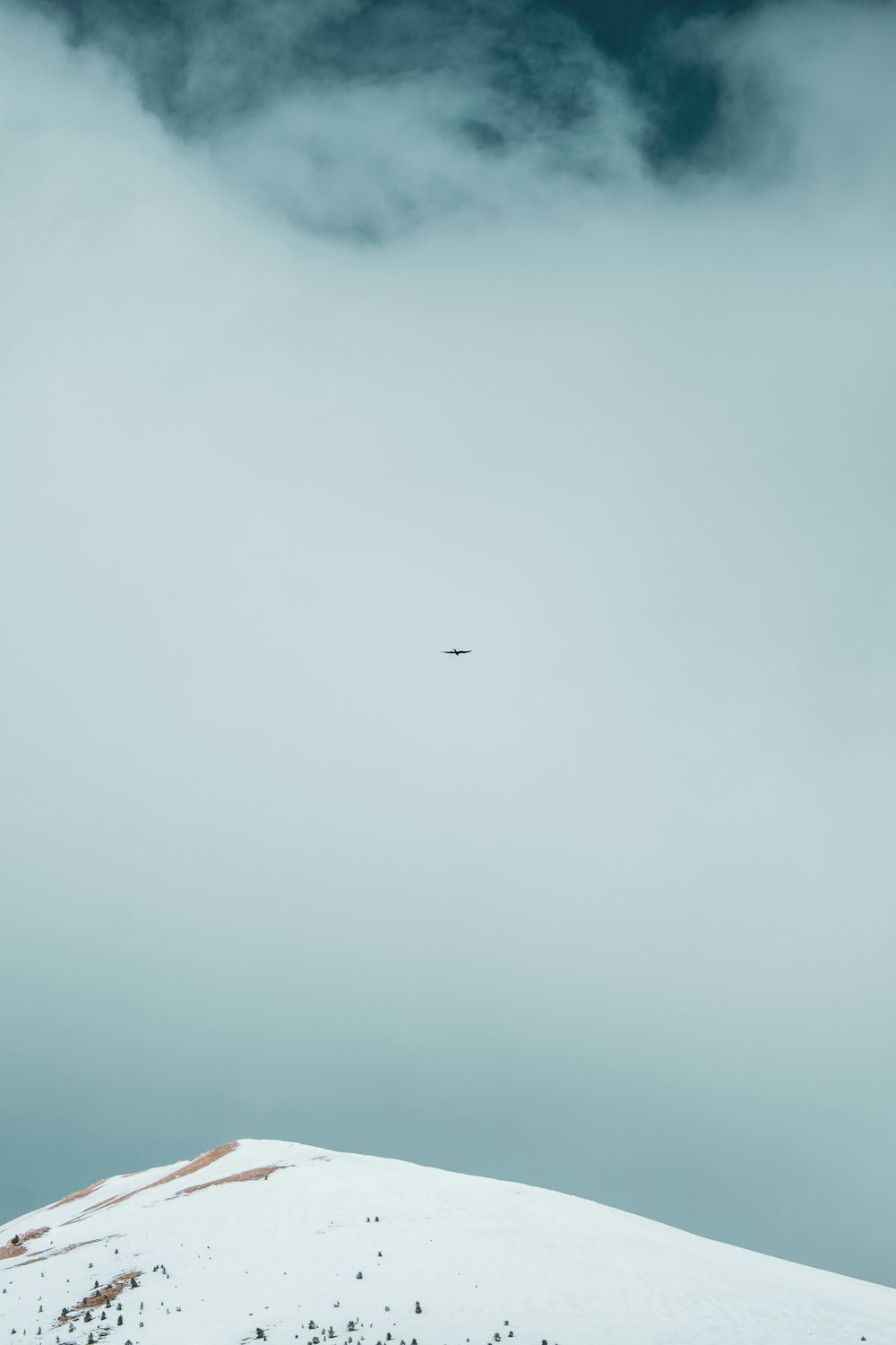 a plane flying over a snow covered mountain