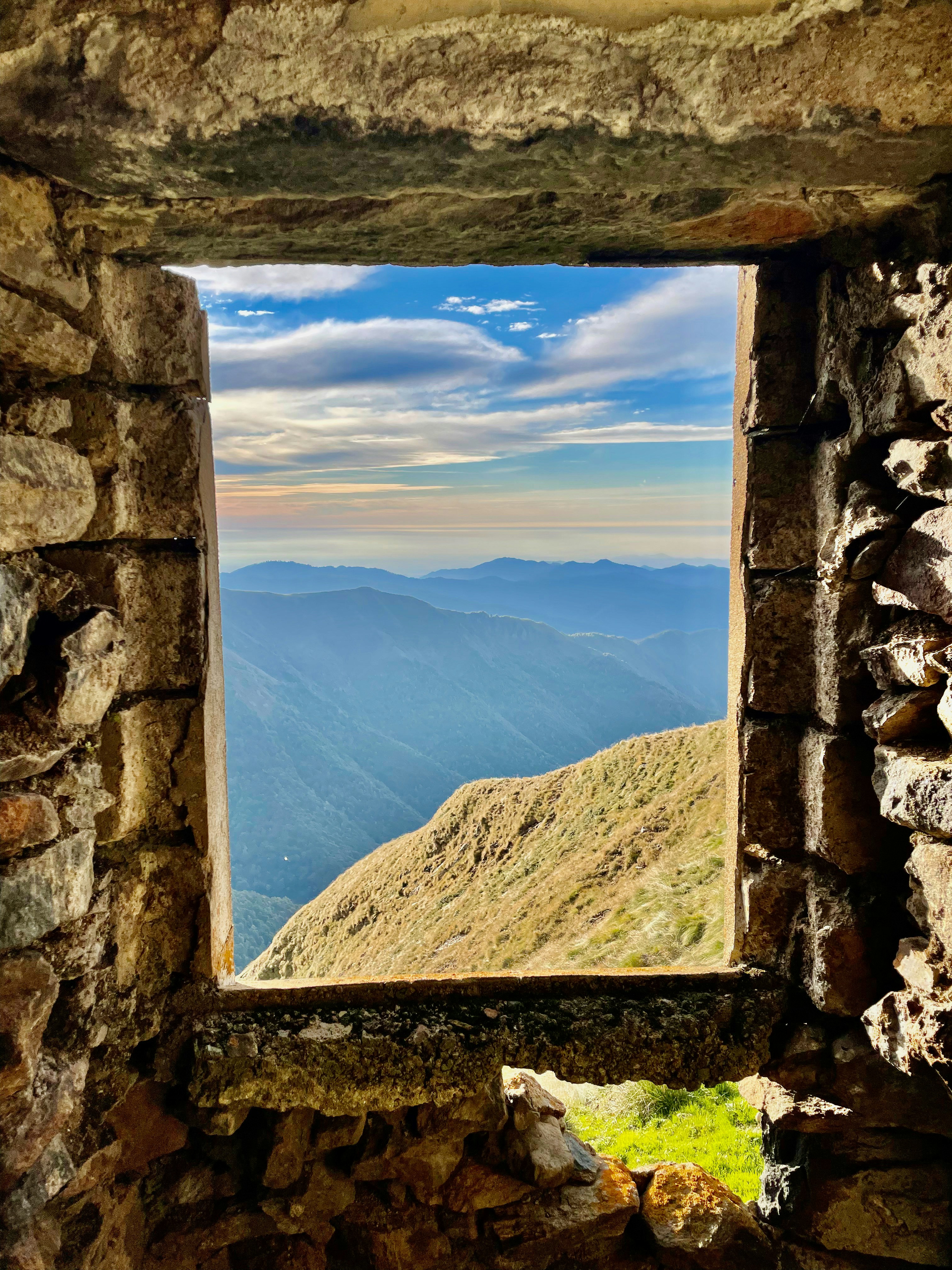 A window in a stone wall with a view of mountains photo – Free Window ...