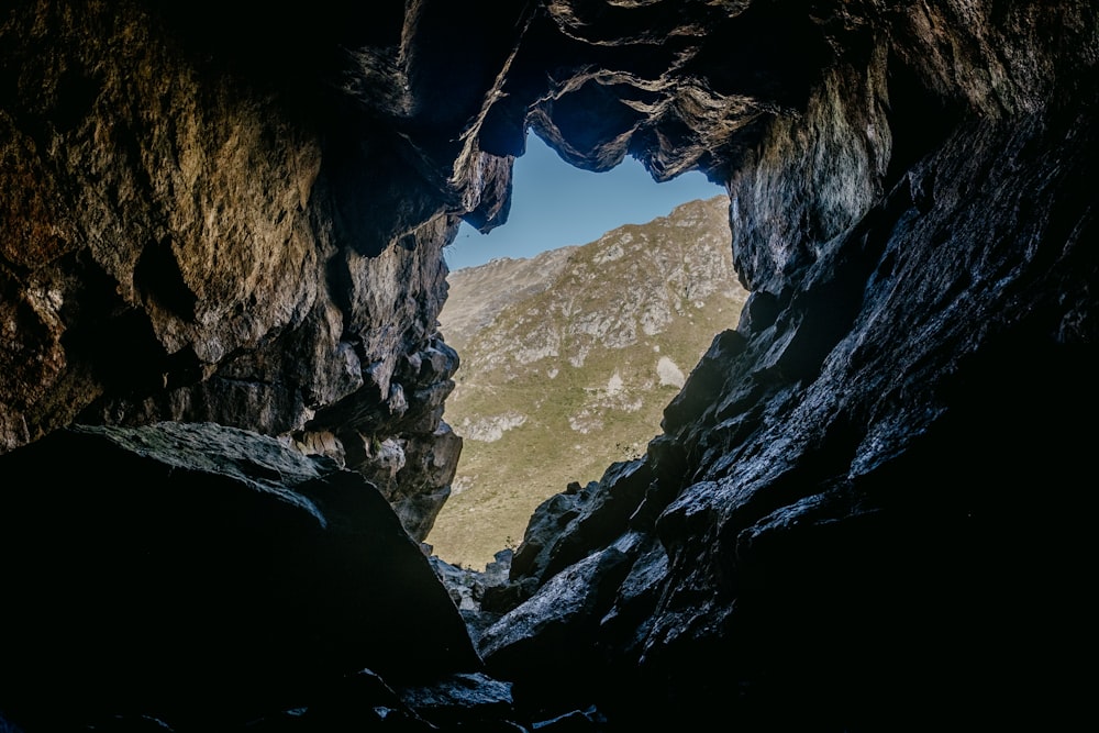 a cave entrance with a mountain in the background