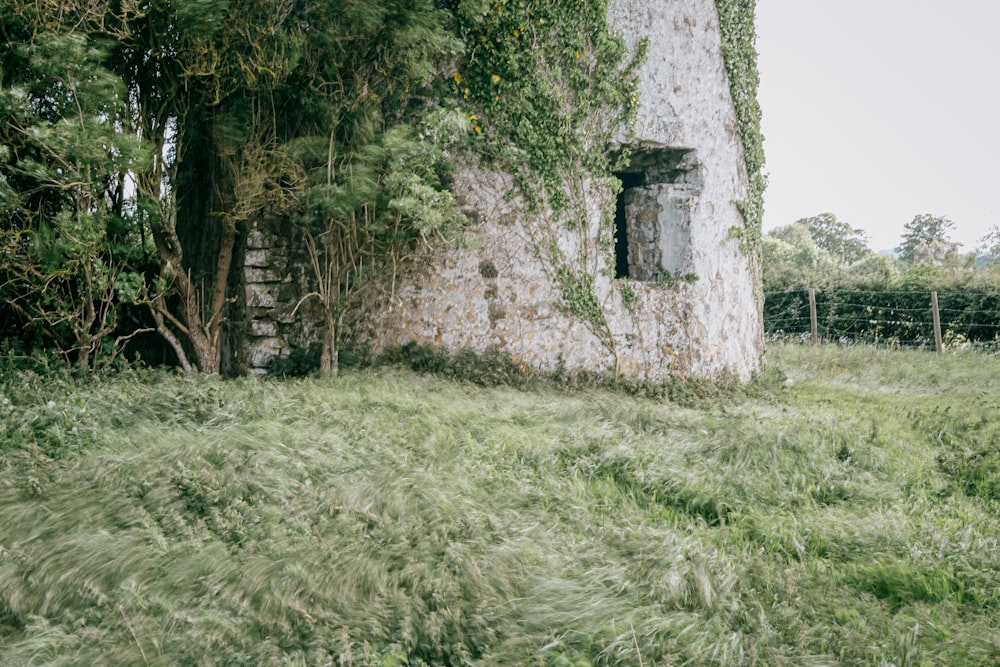 a stone building with a window in the middle of a field