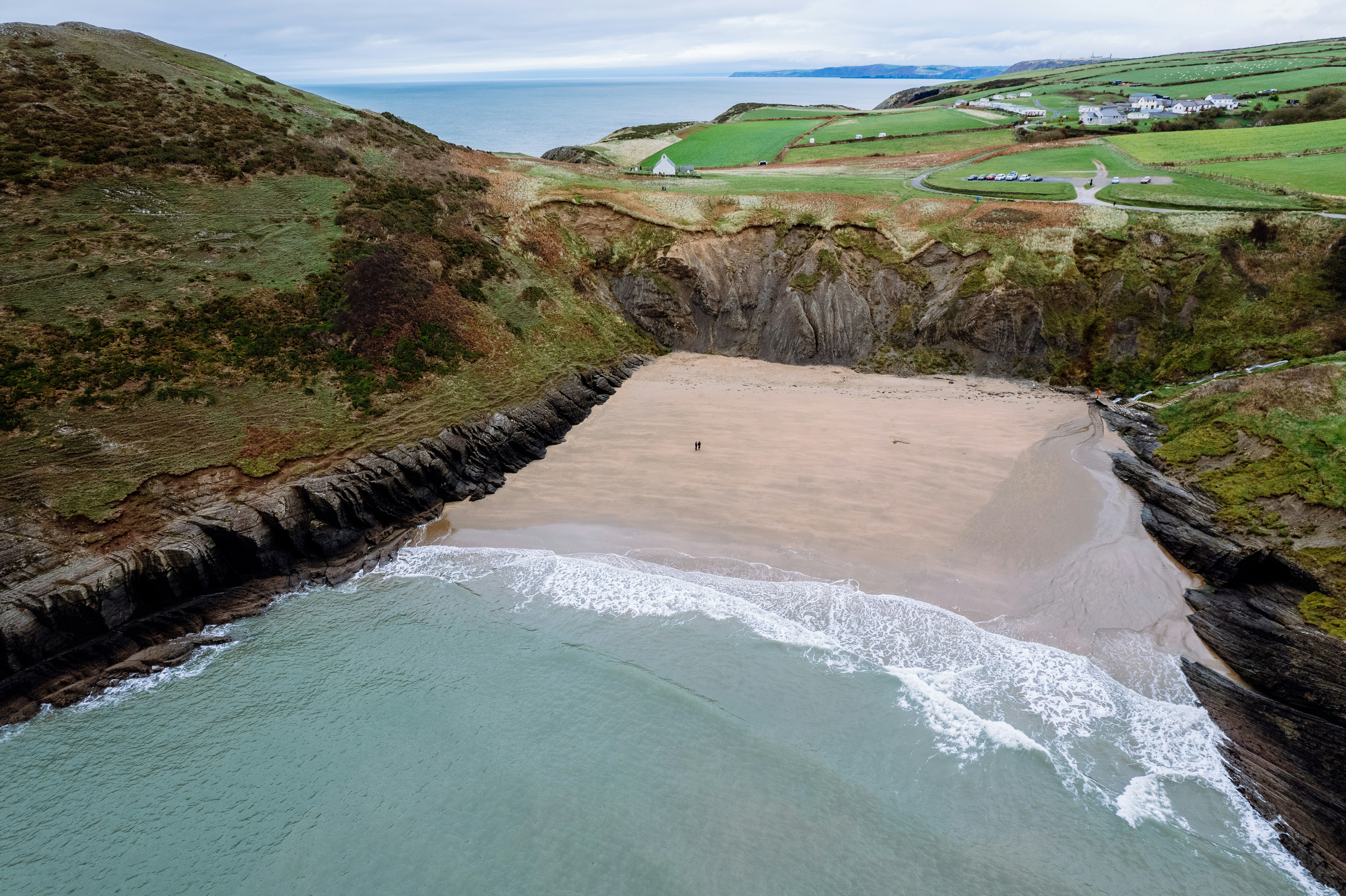 an aerial view of a sandy beach and a body of water