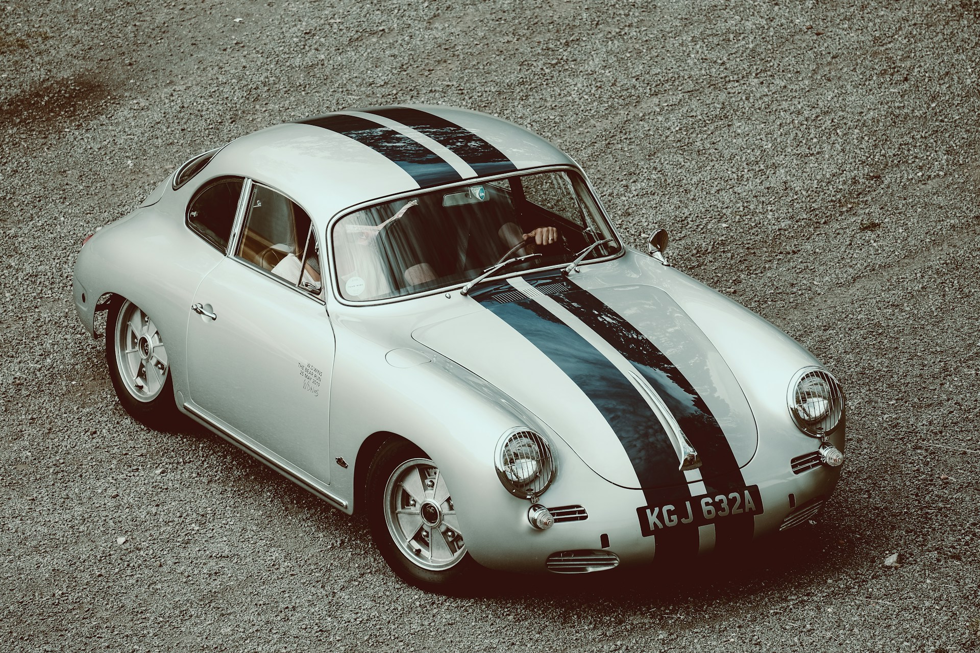a silver car with a black and white stripe on it