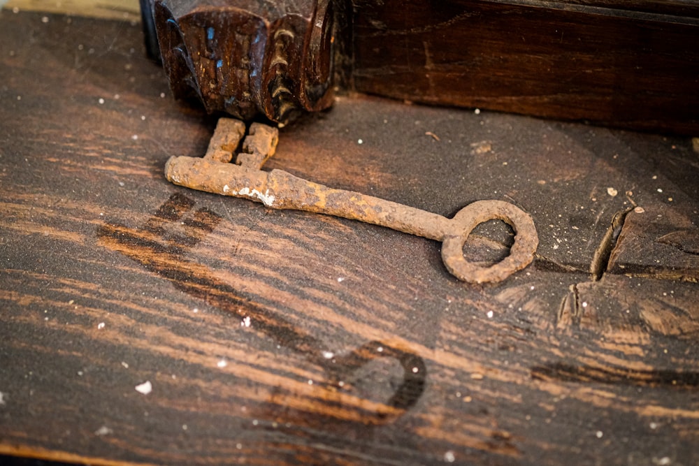 a rusty old key on a wooden table