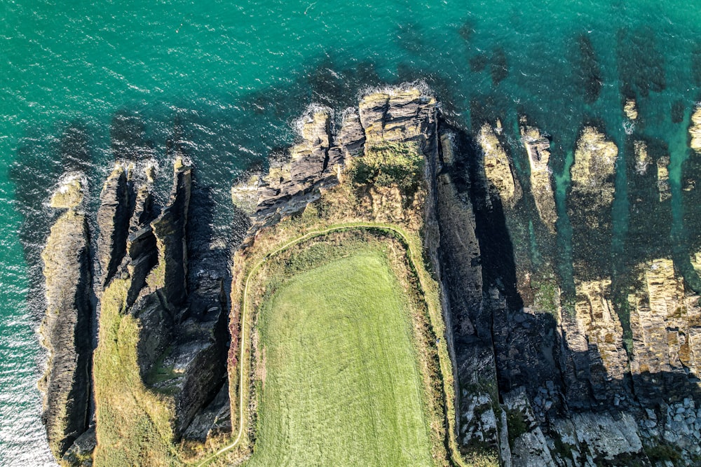 an aerial view of a grassy area next to the ocean