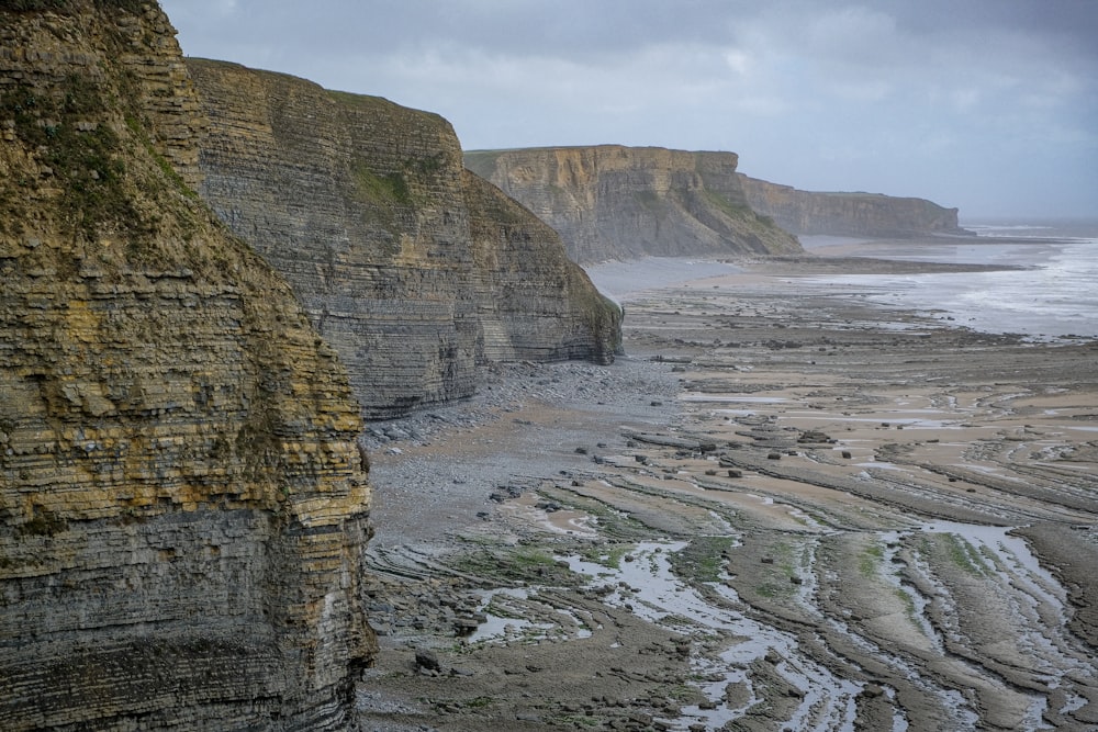 a view of a rocky beach with a cliff in the background