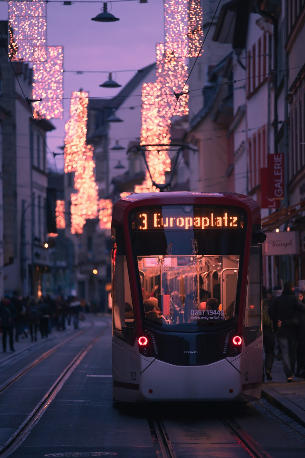 a red and white bus driving down a street