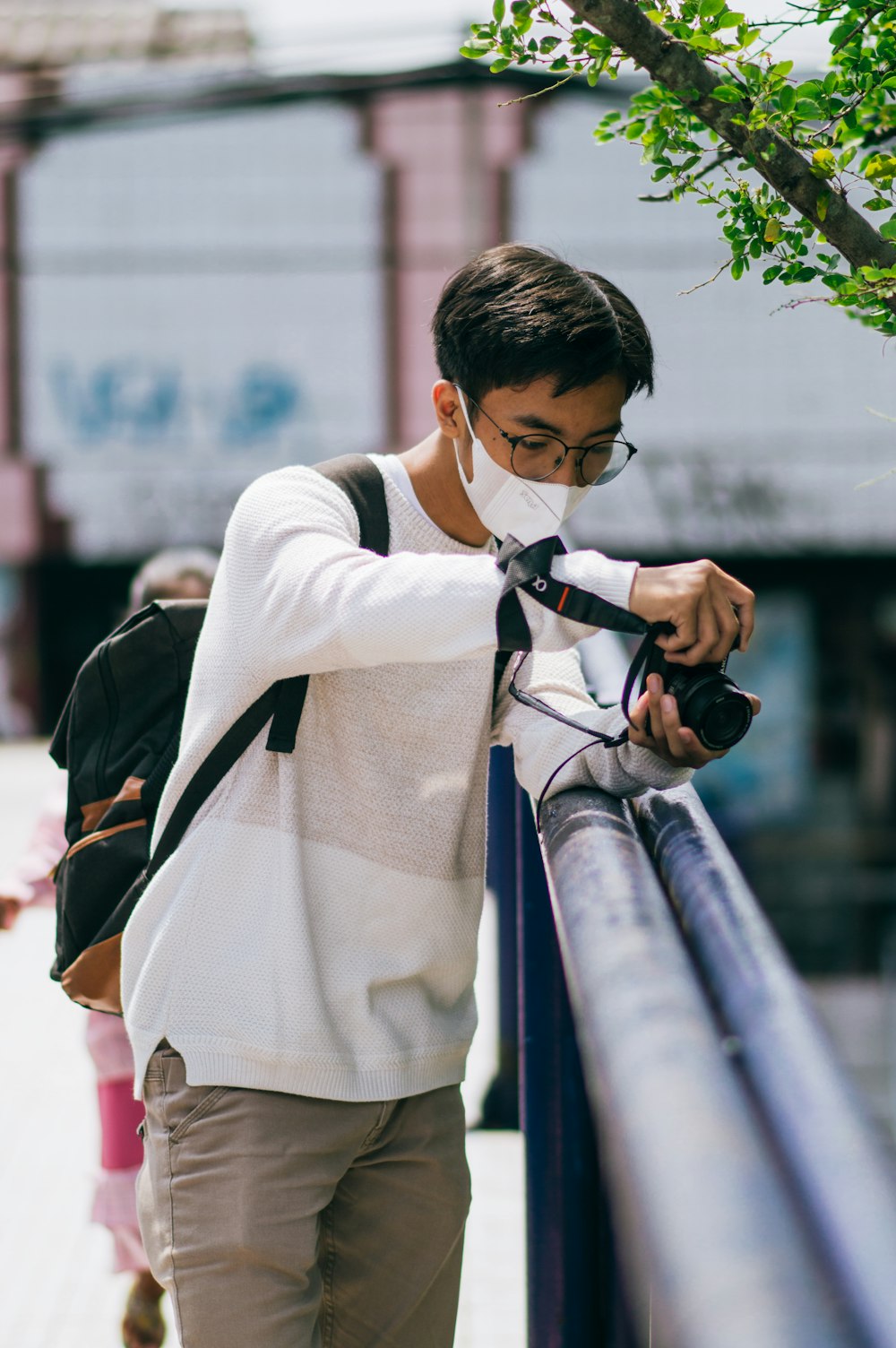 a man wearing a face mask looking at his cell phone