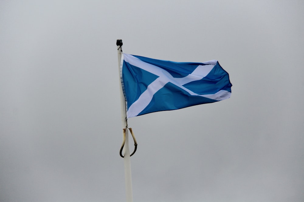 a blue and white flag flying in the wind