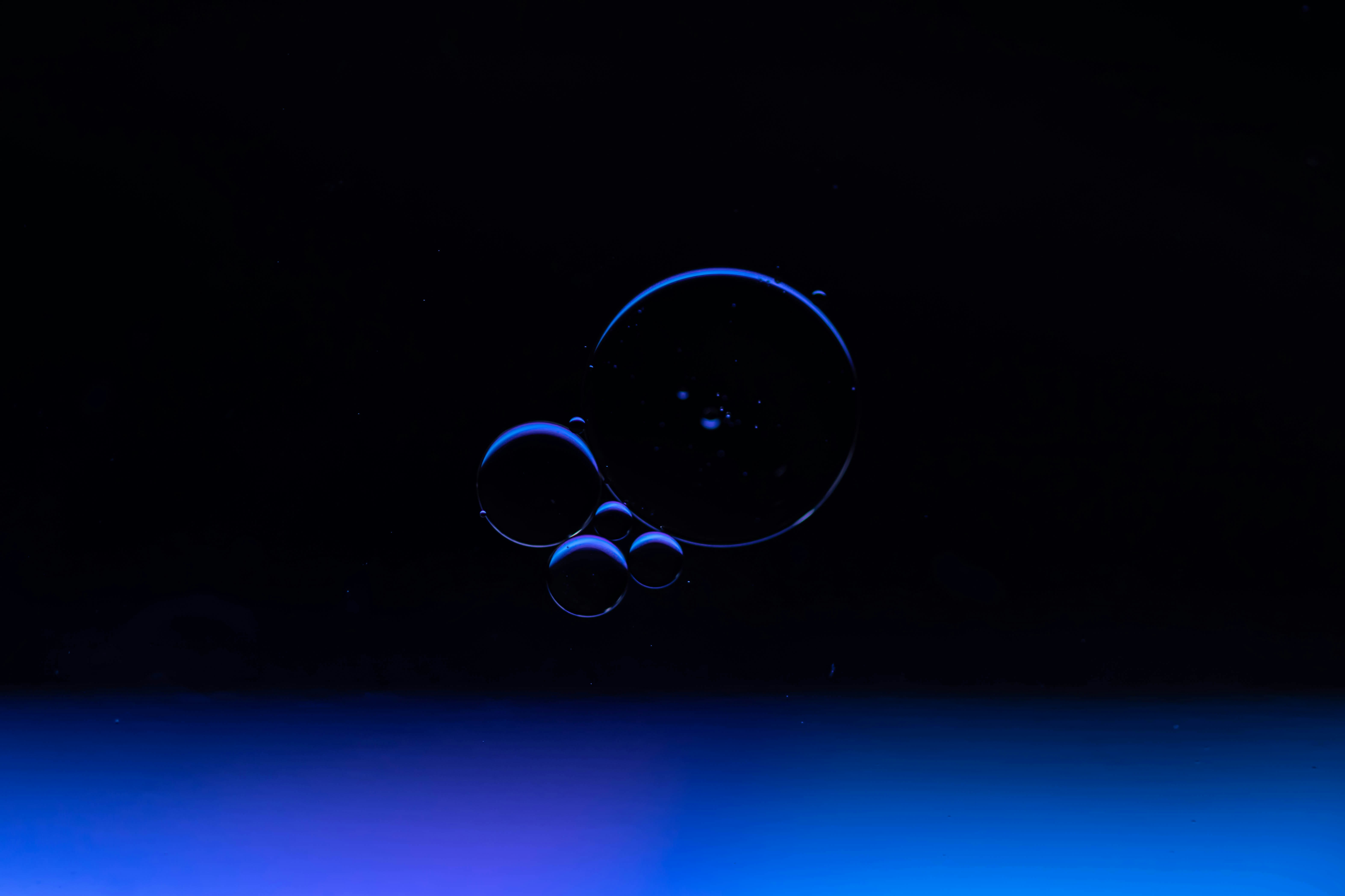 um fundo azul e preto com uma gota de água