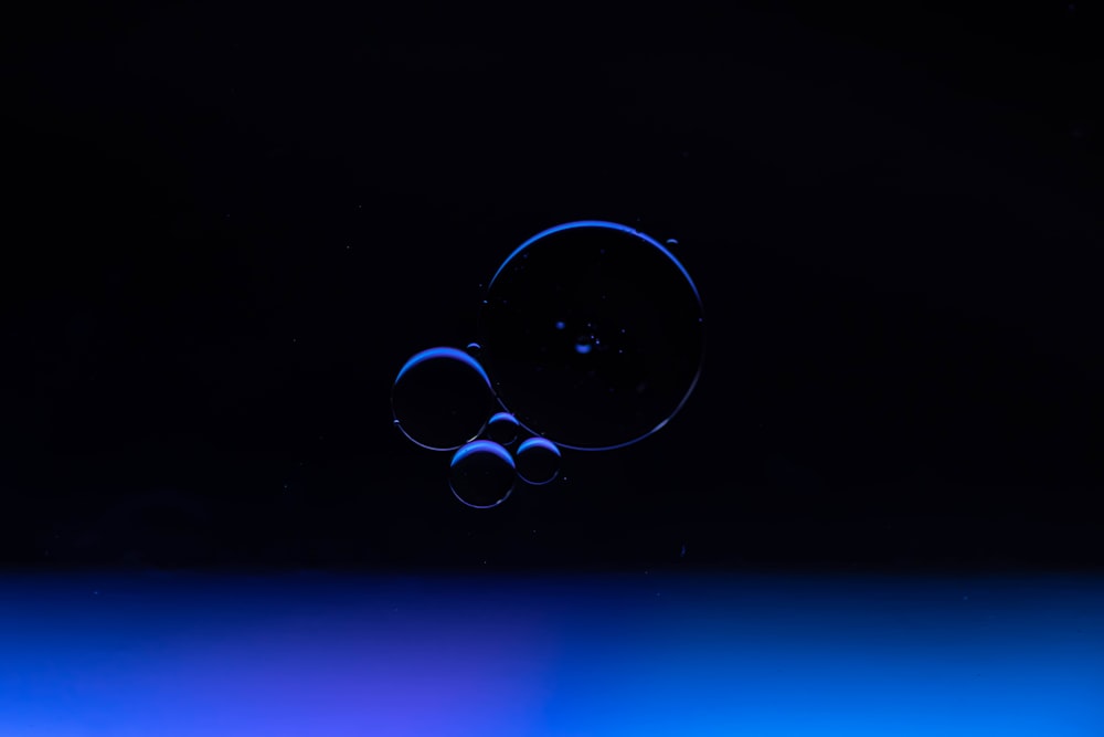 a blue and black background with a drop of water
