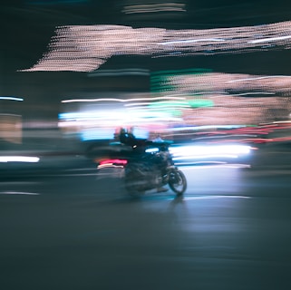 Dynamic shot of an electric motorcycle speeding through a city street at night with neon lights