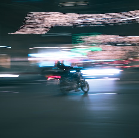 Dynamic shot of an electric motorcycle speeding through a city street at night with neon lights