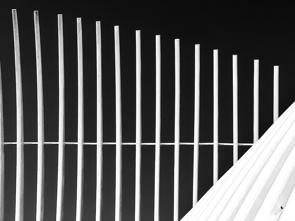a black and white photo of a white fence