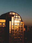 Nighttime shot of a completed building glowing with warm golden lights.