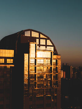 Nighttime shot of a completed building glowing with warm golden lights.
