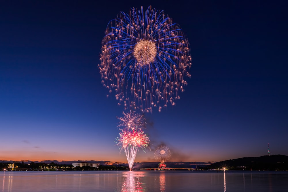 a large fireworks display over a lake at night