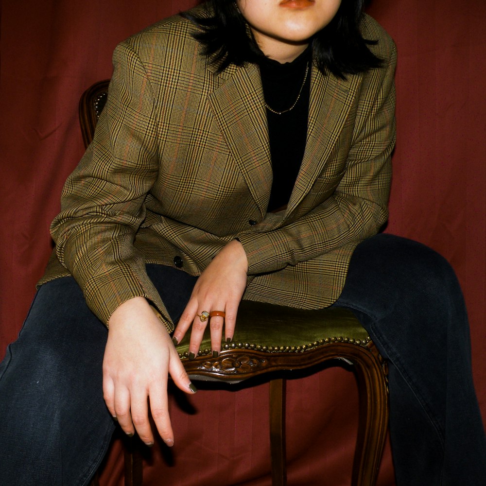 a woman sitting on top of a wooden chair