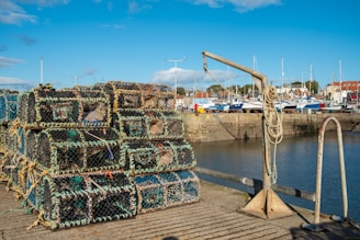a pile of lobster traps sitting on top of a dock
