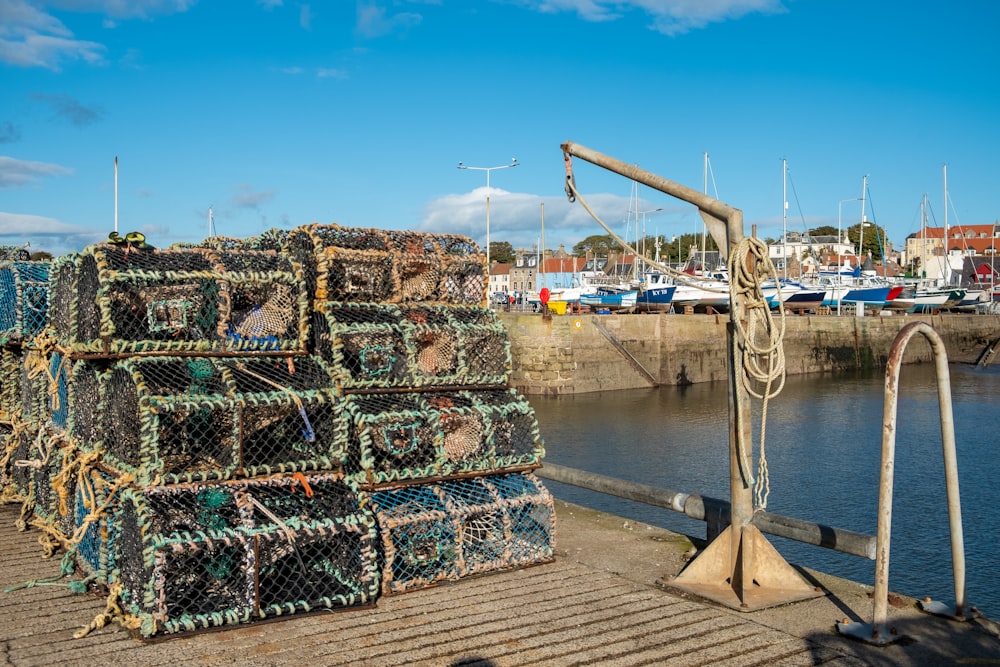 a pile of lobster traps sitting on top of a dock