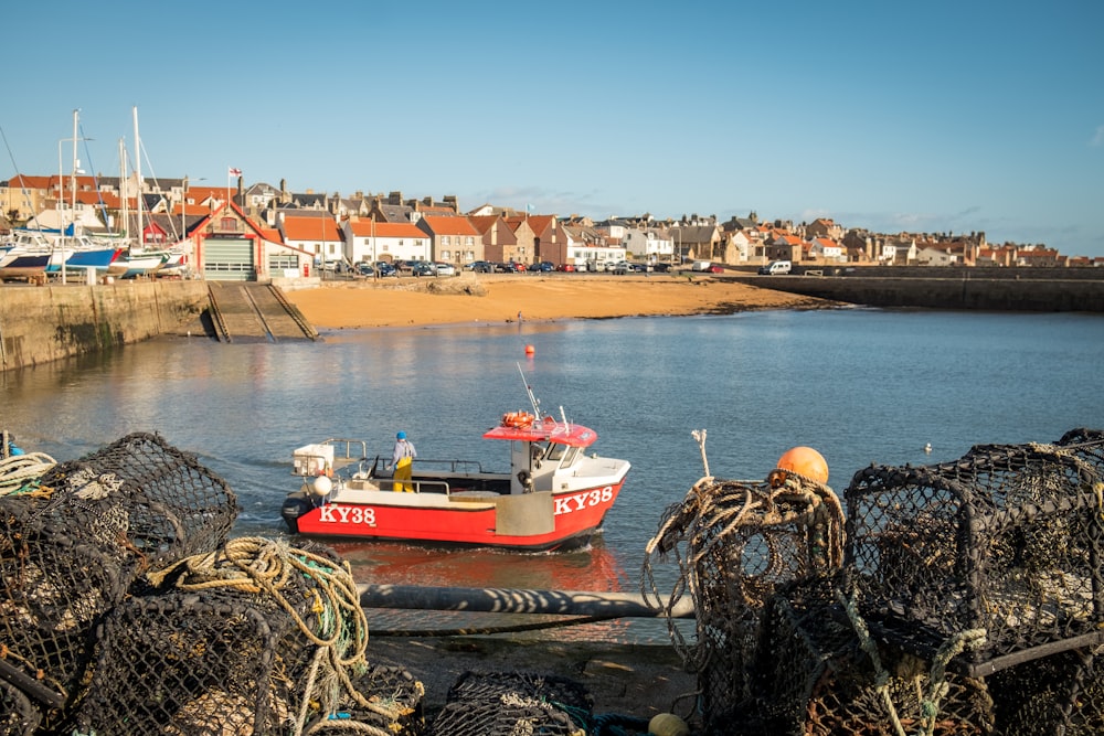 a small red boat sitting in the water