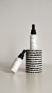 Close-up of Theraderm Black Peel serum bottle with gold accents on a sleek black background