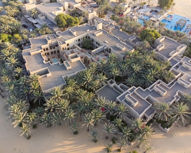 a bird's - eye view of a beach resort surrounded by palm trees proposed in Ghana by luxury builders