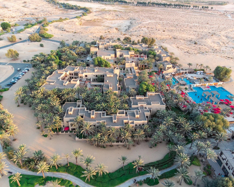 Aerial view of a low-rise resort community surrounded by mature palm trees