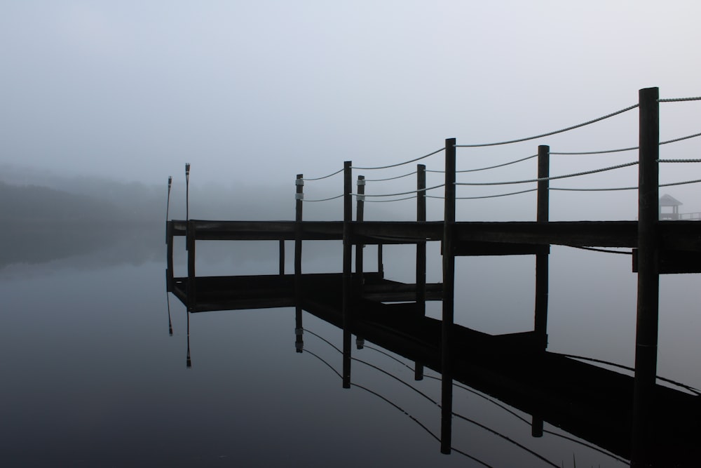 a dock on a lake in the fog