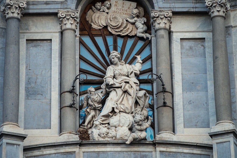 a statue of a woman holding a child on top of a building