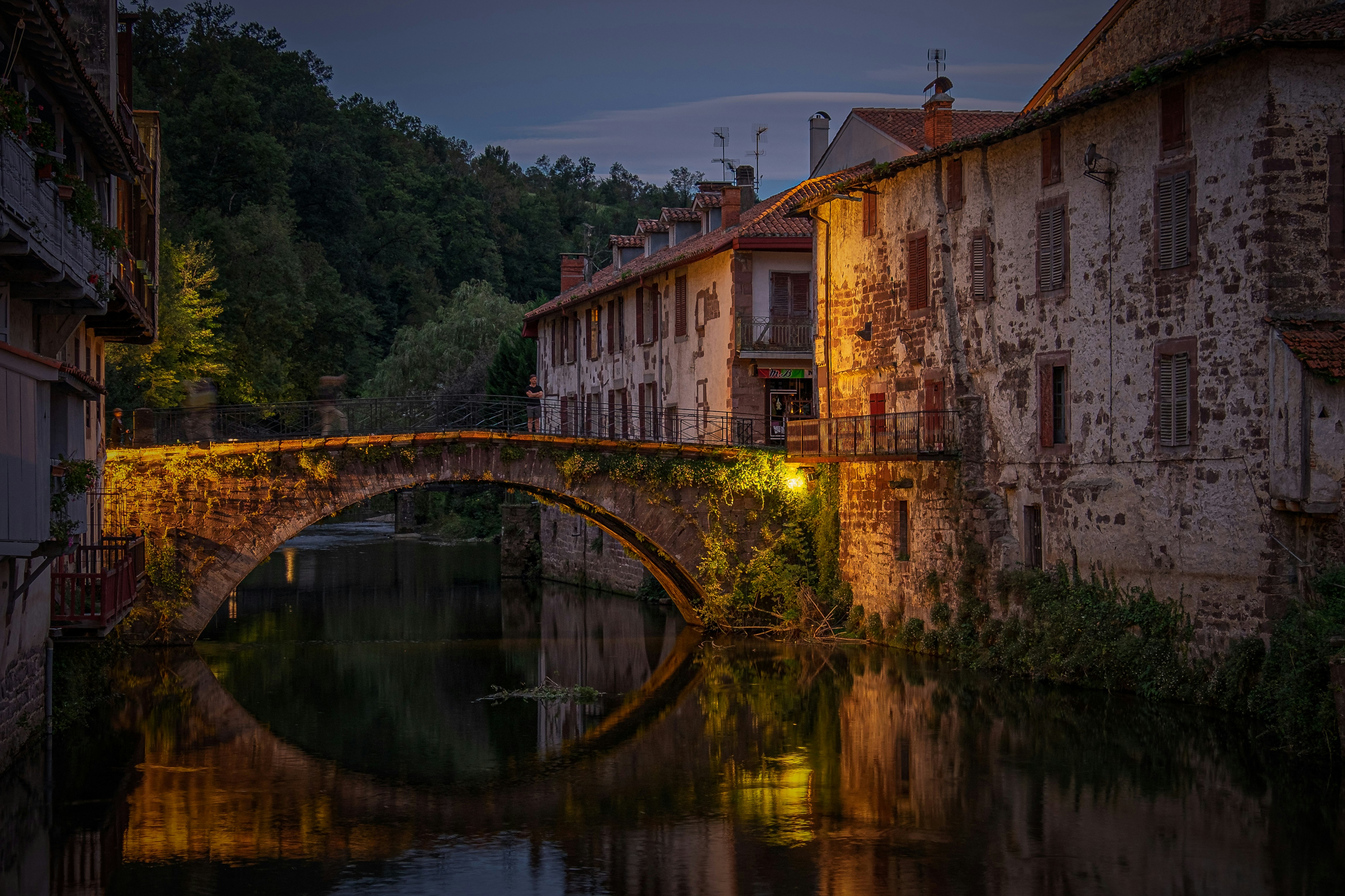 un ponte di pietra su un fiume accanto a una fila di edifici