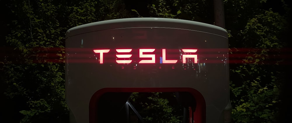 a tesla sign is lit up in the dark