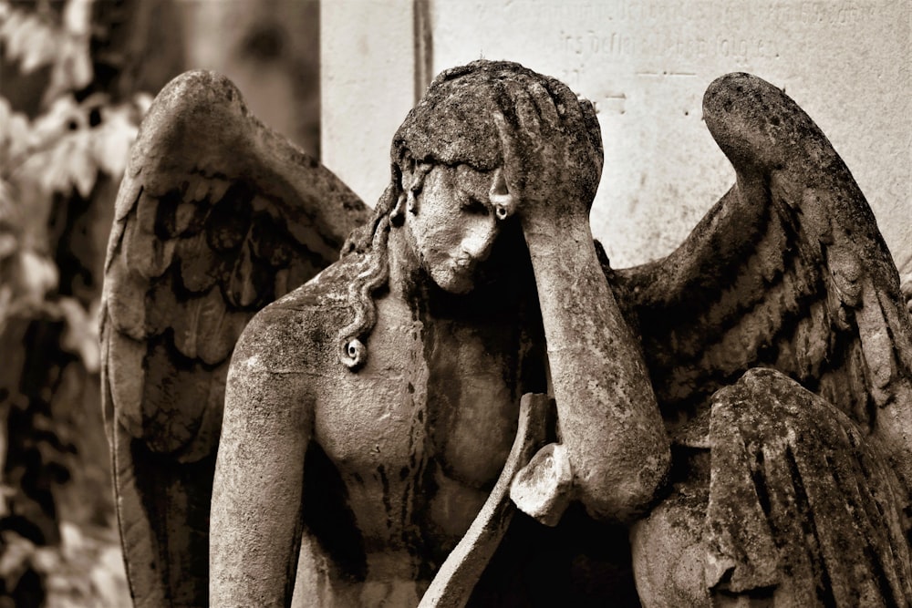 a black and white photo of a statue of an angel