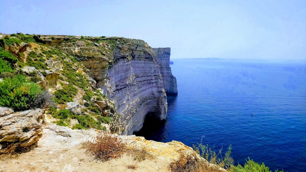 a rocky cliff overlooks a body of water