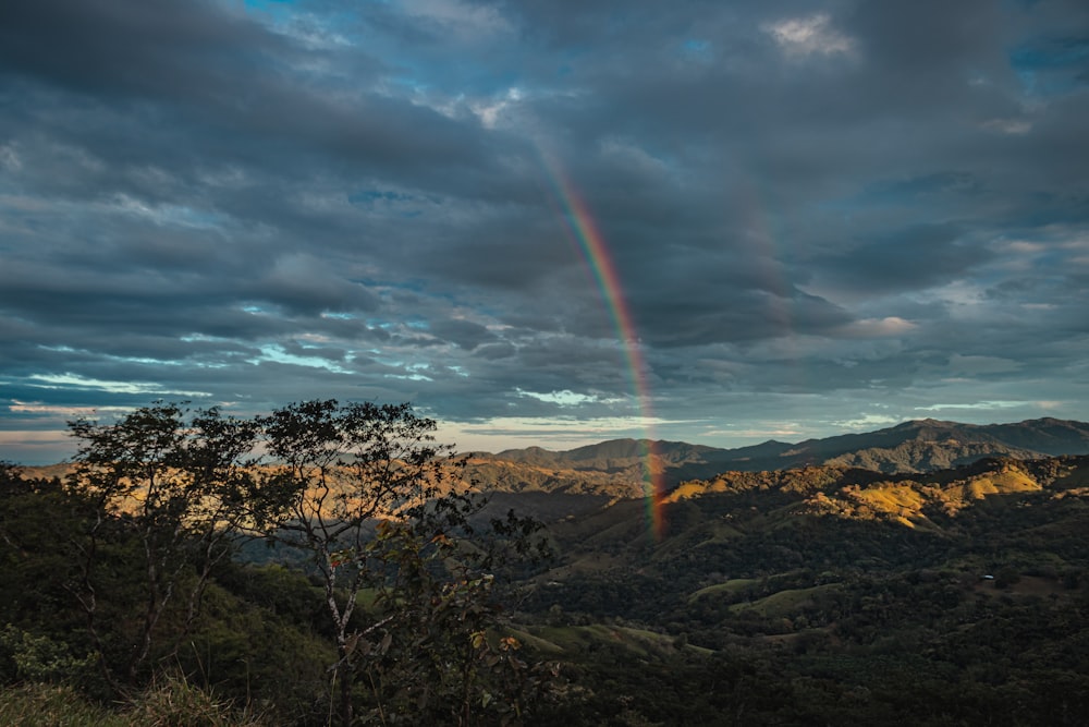 a rainbow in the sky over a mountain range