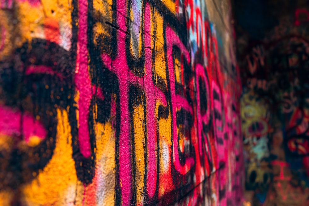 a wall covered in lots of colorful graffiti