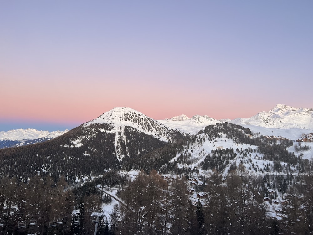 a view of a snowy mountain range at sunset