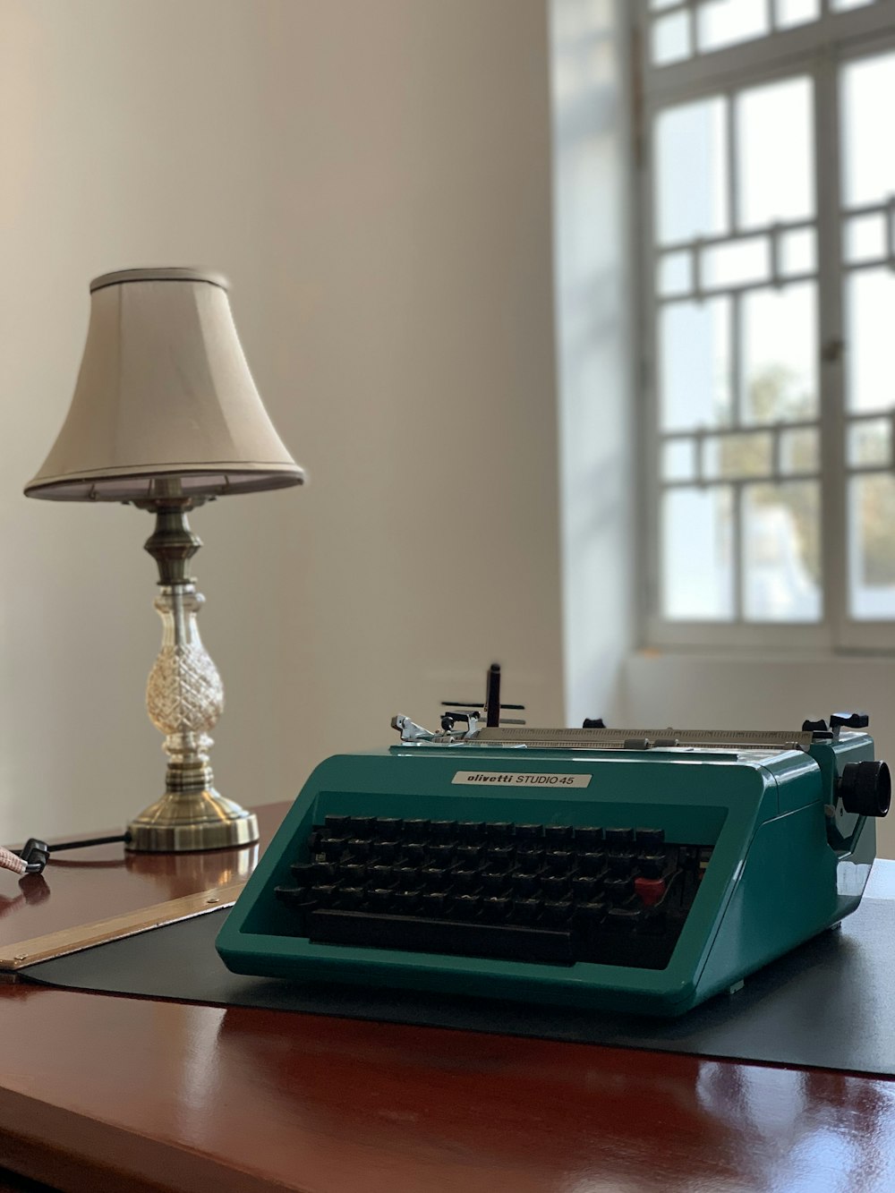 a desk with a lamp and a typewriter on it
