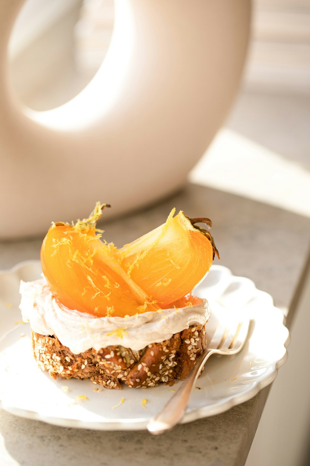 ein weißer Teller mit einem mit Orangenscheiben überzogenen Kuchen