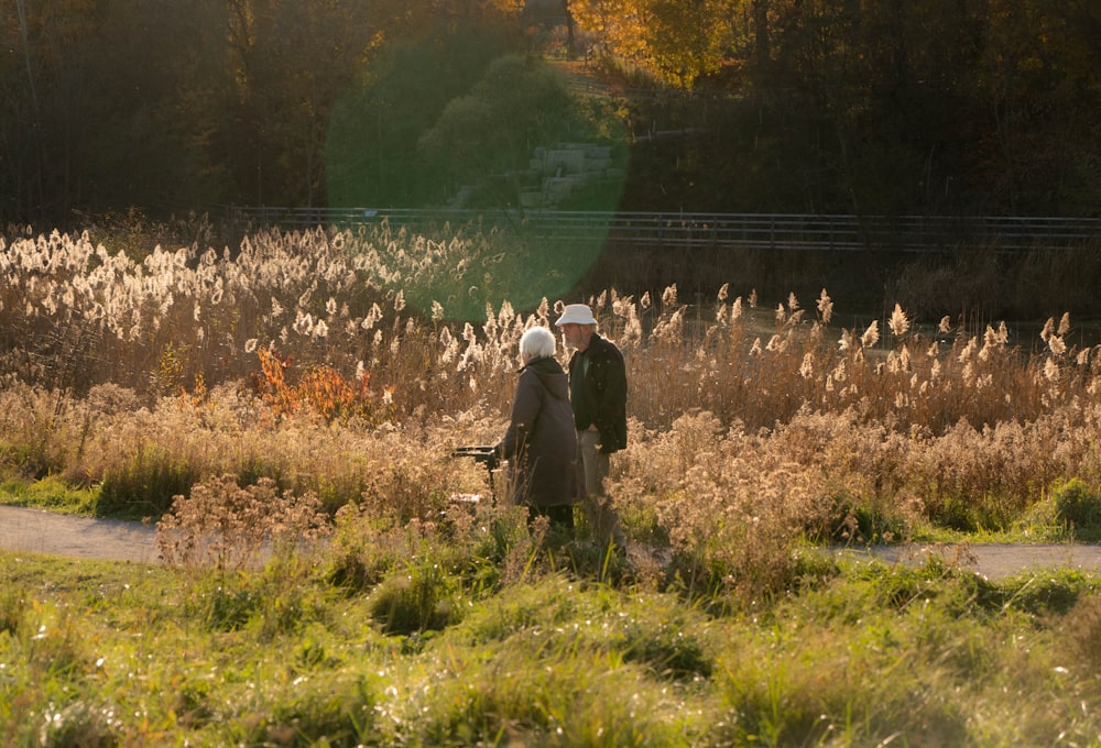 a couple of people that are standing in the grass