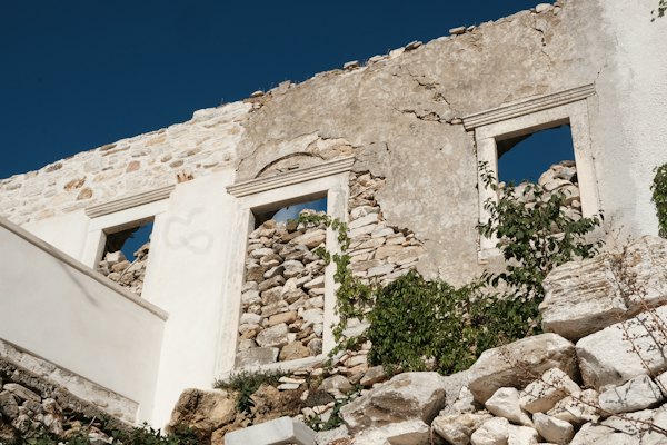 A stone building with two windows on the side of it — Naxos, Greece